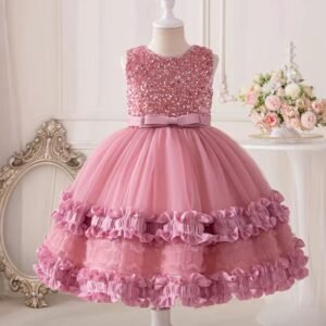 Cette robe est un joli modèle de fête pour enfant, de couleur rose tendre