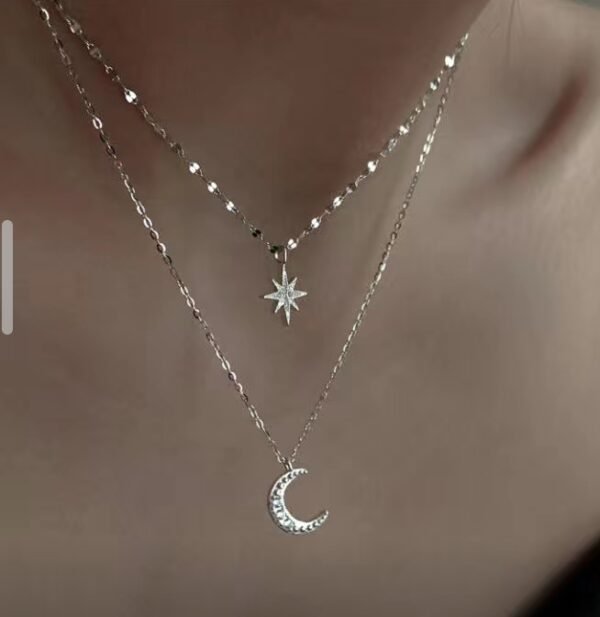 Ce collier raffiné à double chaîne est un parfait mélange d'élégance et de délicatesse. Il est orné d'un pendentif en forme d'étoile et d'une lune incrustés de cristaux brillants, symbolisant la beauté céleste